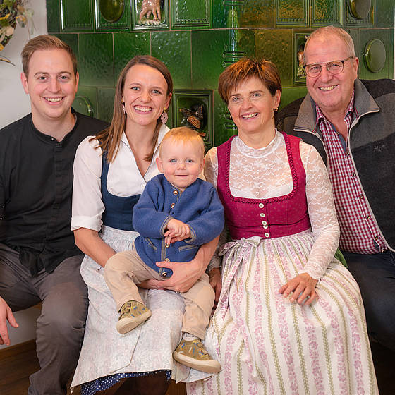 Familie Sampl vor einem Kamin im Wirtshaus.